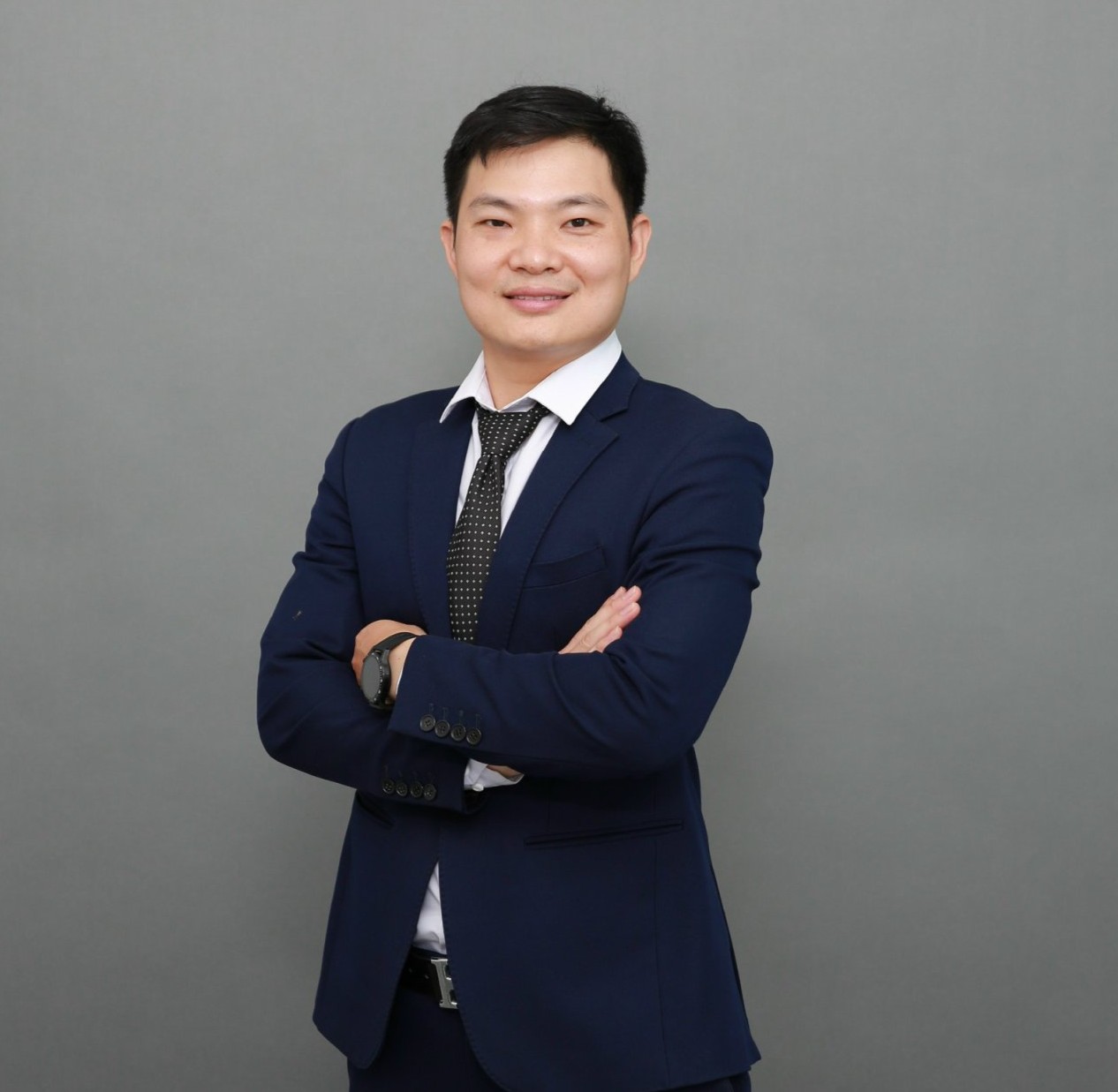 Nguyễn Văn Khương mặc áo vest, khoanh tay